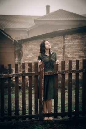 woman standing beside fence